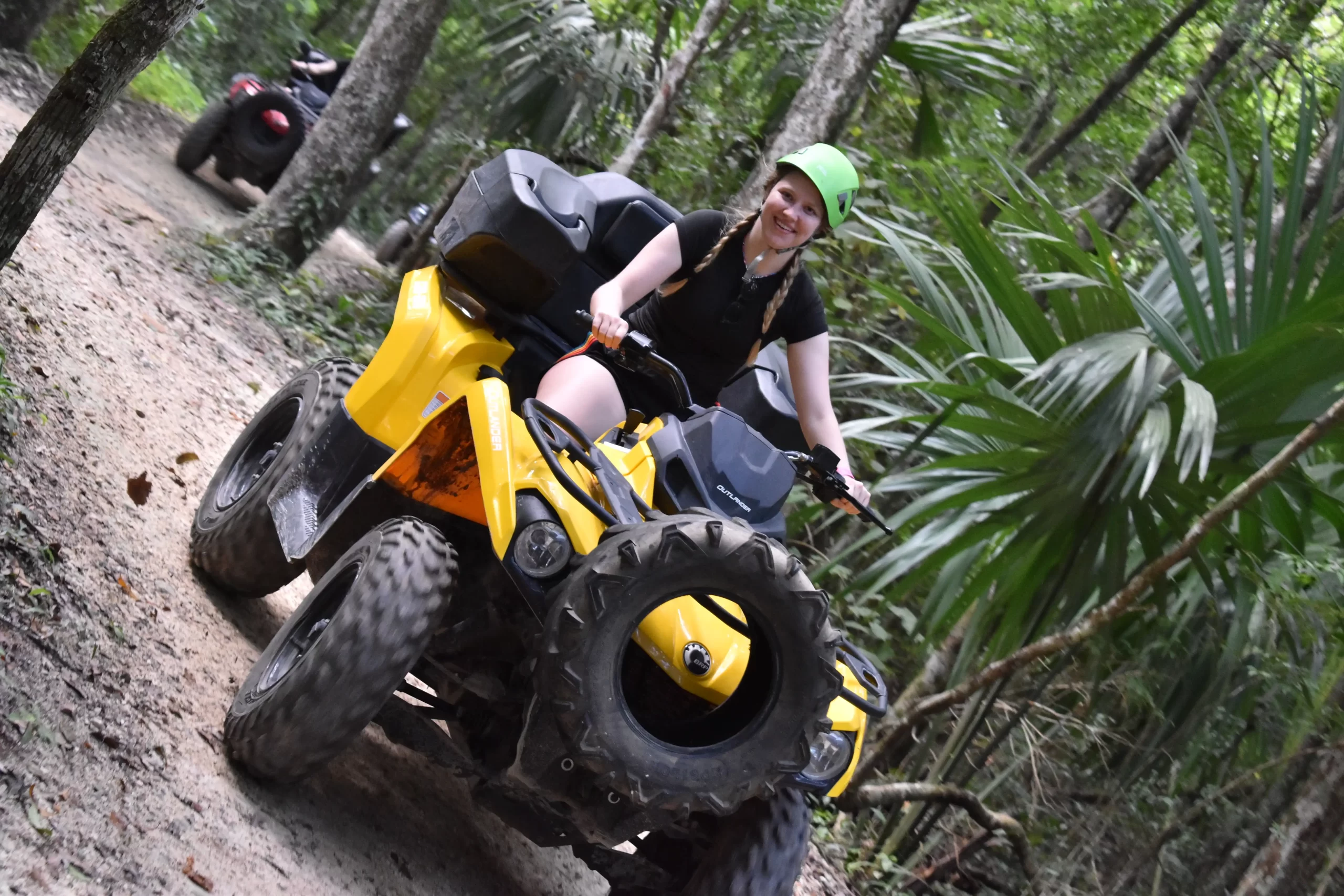 Adventurer riding an ATV through Cancun's jungle, followed by a zipline experience.
