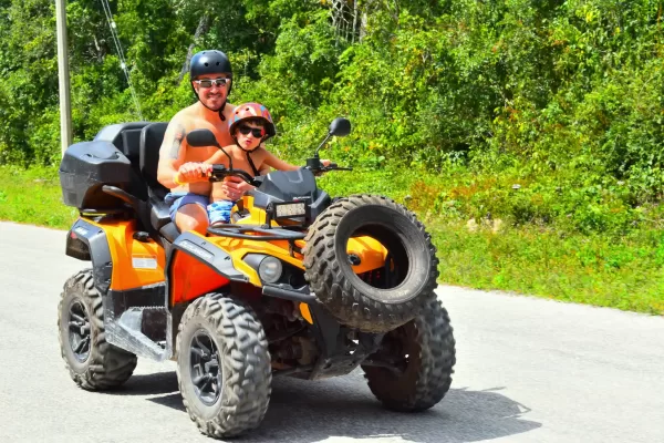 Father and child enjoying a Cancun ATV ride adventure.