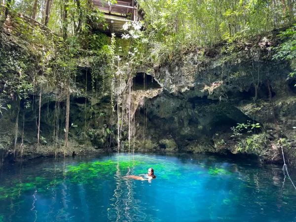 Swimmer enjoying a serene cenote in Cancun's jungle