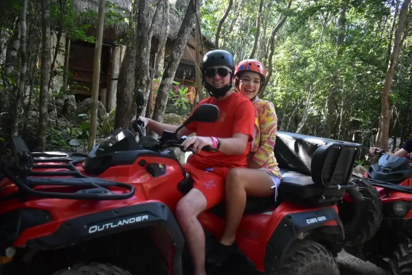 Couple riding an ATV through the Cancun jungle on an adventure tour