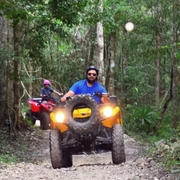 Adventurers riding ATVs through the jungle in Cancun