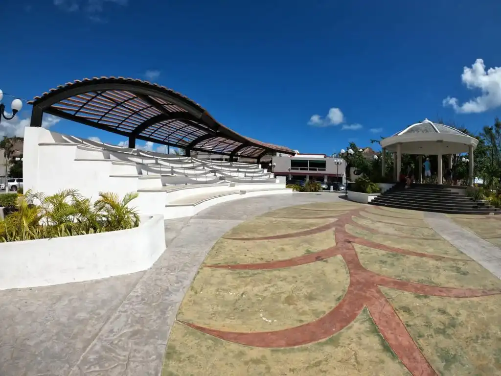 An open-air amphitheater and gazebo in downtown Puerto Morelos, bathed in sunlight.